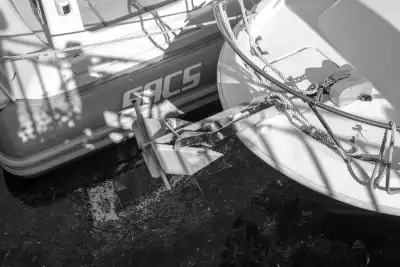 Schwarz-Weiß Aufnahme; Zu sehen ist der Anker eines kleinen Motorboots, am Bug.