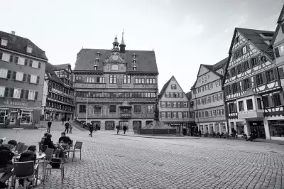 Schwarz-Weiß Aufnahme; zeigt die Vorderseite des bereits 1435 gebauten Rathauses und den Marktplatz in Tübingen.